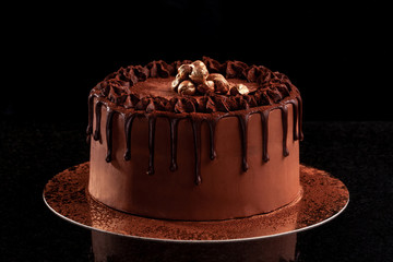 Chocolate cake with nuts on a black background
