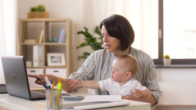 multi-tasking, freelance and motherhood concept - working mother giving pen to baby boy at home office