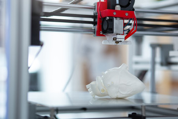 Exact replica. The close up of a 3D printer creating a model of heart and recreating all the...