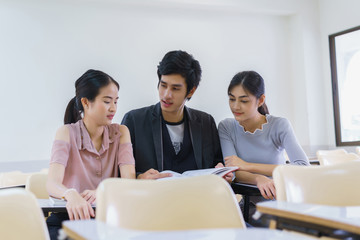 Students man and woman reading book preapare for exam highschool in classroom at school. concept of education people learning and tutorial academy.