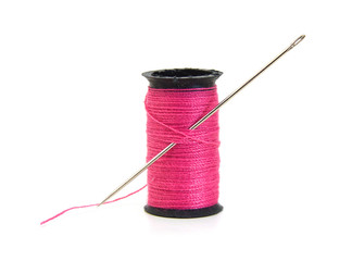 Spool of pink thread and needle isolated on white background