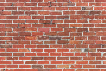 Fototapeta premium brick wall of red brick with cracks and gray cement