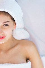 Young beautiful woman lying on the bed with happy spa body and scrub skin at spa salon. concept of relaxing health aroma spa, treatment and body massage.