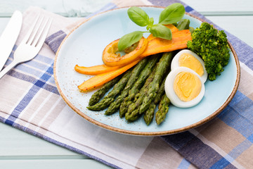 Fried asparagus with broccoli and lemon and carrot.