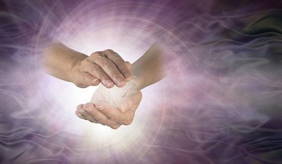 Vortex spiralling between hands - female cupped hands with white vortex energy between on a purple...