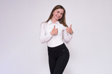 portrait of a beautiful brunette girl on a white background in a white shirt showing on a product.