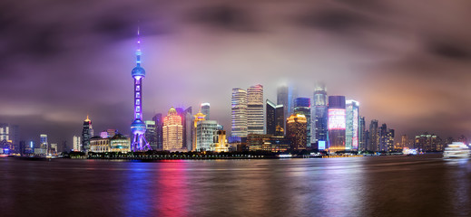 Panorama der beleuchteten Skyline von Shanghai, China, am Abend mit Nebel