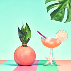 Tropical Grapefruit with Cocktail on Beach. Bright Color. Hot Summer Vibes. Trendy fashion Style. Creative Art. Fun Summer party Mood. Minimal