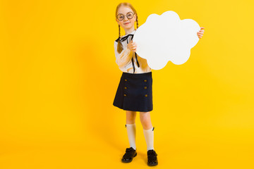 Girl with red pigtails on a yellow background. A charming girl in round transparent glasses is holding a white cloud in her hands.