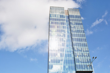 Skyscraper on a background of blue sky with clouds