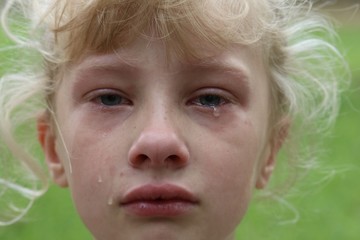 Closeup of a young girl with tears rolling down her cheek