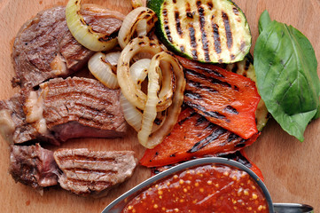 Beef steak. Juicy grilled beef steak with marks and vegetables on the wooden board