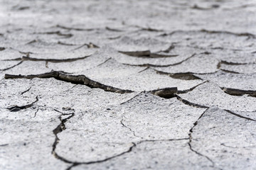 background - cracked dry sun-dried clay crust in a waterless desert