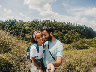 .Young and inlove couple in their honeymoon travling around Bali, Indonesia. Enjoying a day of sightseeing together discovering incredible jungle landscapes. Travel Photography.