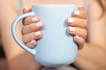 Woman sitting with a mug of tea in hands hot healthy care