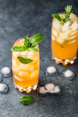 Fresh summer cocktail with orange juice and ice cubes. Glass of orange soda drink on dark background