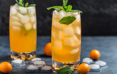 Fresh summer cocktail with orange juice and ice cubes. Glass of orange soda drink on dark background