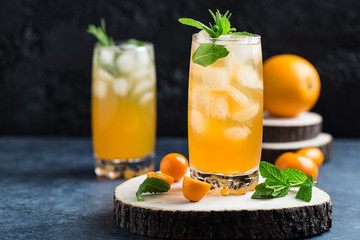 Fresh summer cocktail with orange juice and ice cubes. Glass of orange soda drink on dark background