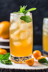 Fresh summer cocktail with orange juice and ice cubes. Glass of orange soda drink on dark background