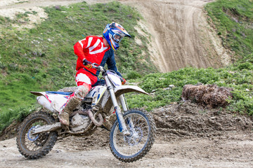 Naklejka premium Professional Motocross Motorcycle Rider Drives Over the Road Track.