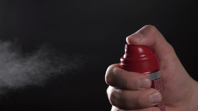 Close-up view of human hand and spray bottle isolated on black parfume moscito spray insects