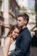 The lovely couple in love embarcing and standing on the street