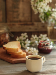 Obraz na płótnie Canvas black coffee in a white cup and flowers (portion of hot coffee)