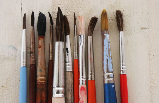Row of paint brushes on a table