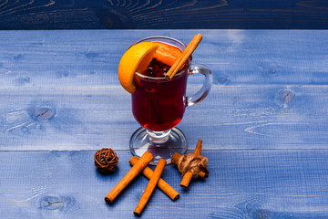 Drink or beverage with orange and cinnamon. Glass with mulled wine or hot cider near cinnamon...