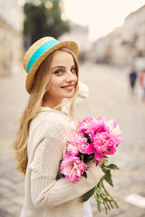 Young blonde girl with pink flowers and hat