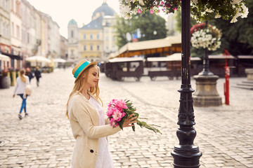 Fototapeta premium Young blonde girl with pink flowers and hat