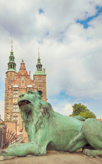 Fototapeta na wymiar Copenhagen - beautiful view of Rosenborg castle from the King's garden with a bronze lion at the entrance gate. The castle was built as country summerhouse in 1606 in Dutch Renaissance style. 