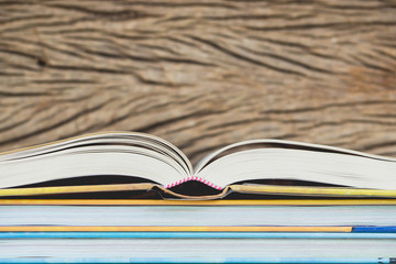 Books stack in front of wooden wall for business, education back to school concept.