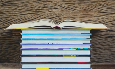 Books stack in front of wooden wall for business, education back to school concept.