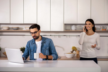 Bearded man using laptop in the kitchen