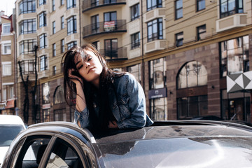 The beautiful girl stands in the car