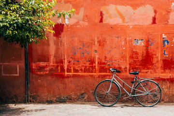 old bike standing at red wall