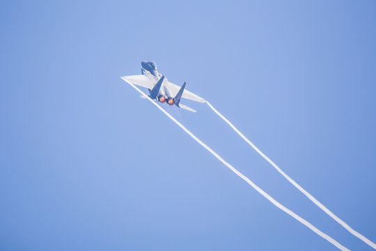 Vapour trails from the wings of an F-15C Eagle from the 48th Fighter Wing as it overflies the runway at RAF Lakenheath after a training sortie.