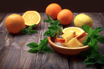 Fresh fruits on a wooden table. Close-up. The concept of proper nutrition and lifestyle. Preparation of refreshing water with ice and fruit, mint.