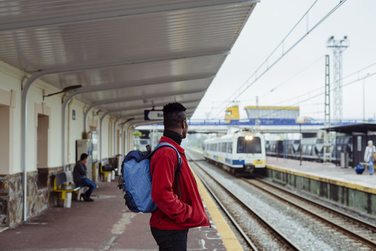 Portrait of young man waiting for train on railway platform