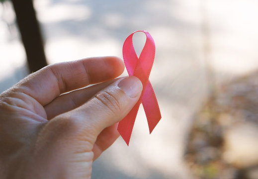 Hand Holding Breast Cancer Awareness Pink Ribbon.