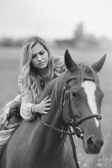 Obraz premium Young woman sits on a horse in a summer meadow