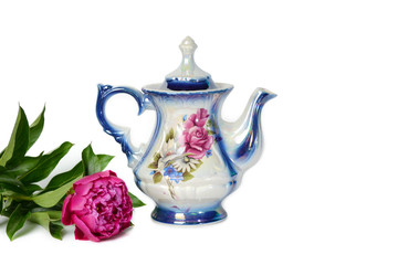 Teapot with a picture of a flower on a white background and a beautiful purple peony.