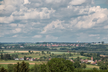 Fototapeta na wymiar Little plane approaching and the green german countryside