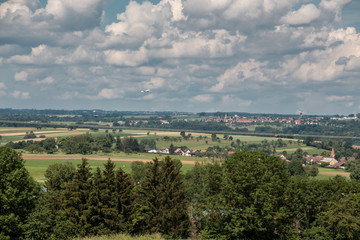 Fototapeta na wymiar Little plane approaching and the green german countryside