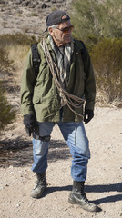 Man on a hike in the mountains with survival gear.