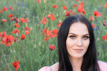 Naklejka premium Brunette in poppy field portrait