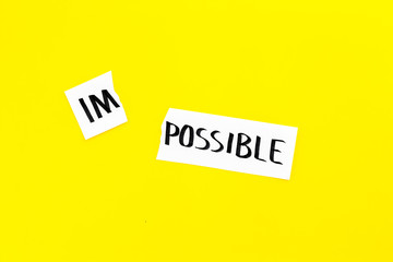Belief in yourself concept. Cutting the part im of written word impossible by sciccors. Yellow background top view copy space