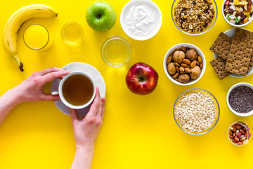 Fototapeta na wymiar Ideas of healthy hearty breakfast for sportsmen. Fruits, oatmeal, yogurt, nuts, crispbreads, chia on yellow background top view copy space