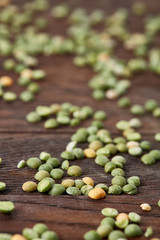Green peas on rustic wooden background, close-up, top view, selective focus, shallow depth of field.